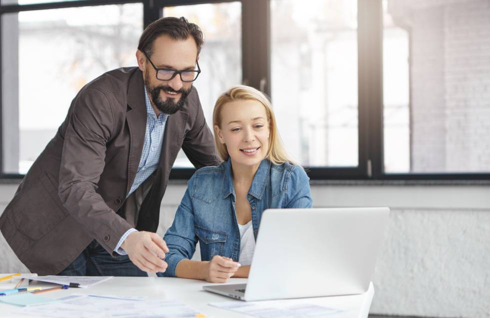 Image of talented female and male coworkers search information in network for future startup project, use presentation, plans work schedule or make online conference with partners. Cooperation concept